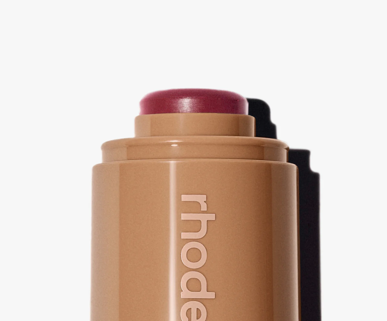 Cosmetic blush stick with 'rhode' branding on a white background