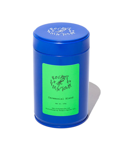 Blue cylindrical tea canister with green label on a white background