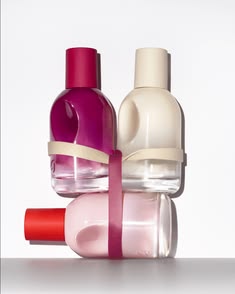 Three colorful bottles with ribbons on a white background