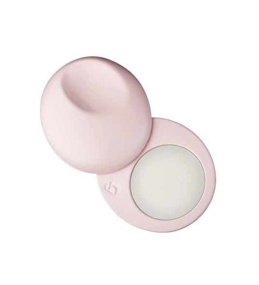 Pink compact case with a white round item inside on a white background