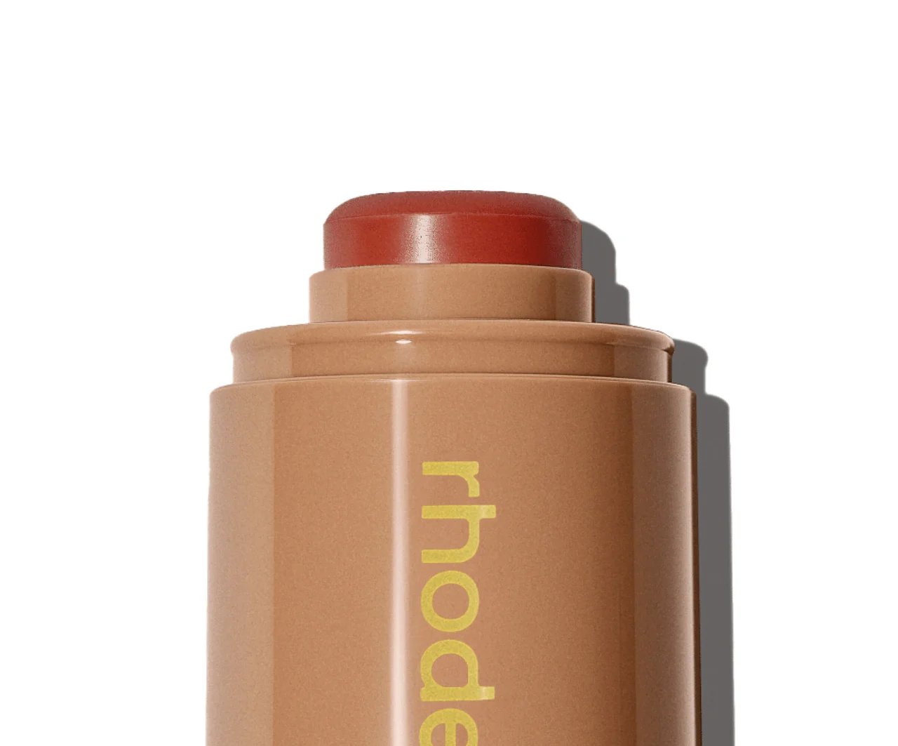 Cosmetic stick with 'rhode' branding on a white background